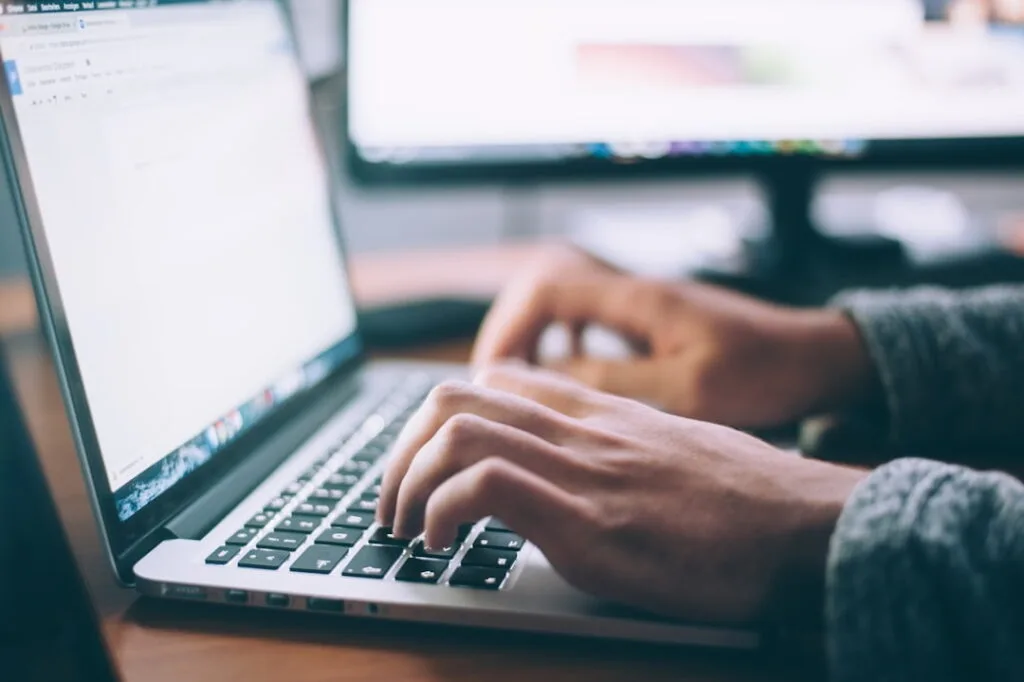 A closeup of someone typing on their work laptop.